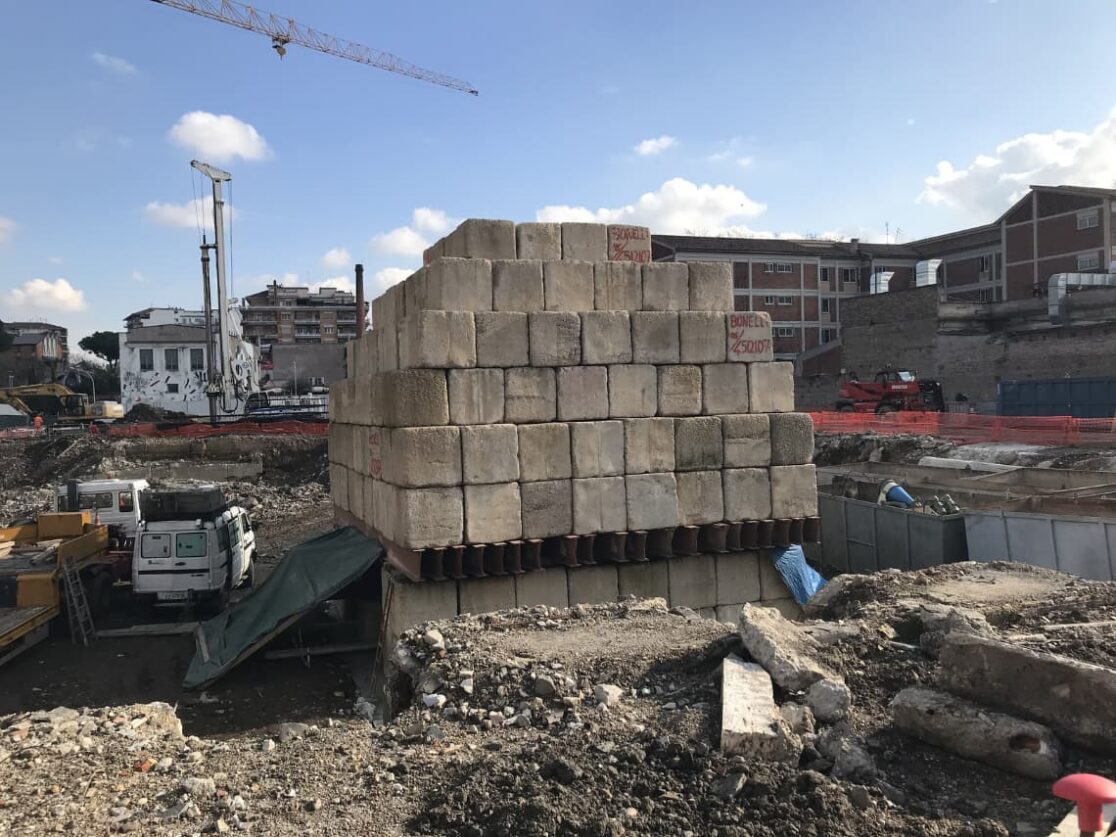 Pila di mattoni su cantiere per la costruzione del nuovo Rettorato dell'Università Roma Tre, con fondamenta solide e stabili fino a 45 metri di profondità.